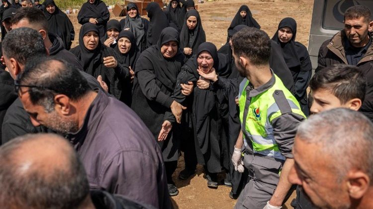 Parentes choram enquanto pessoas baixam o corpo coberto por um sudário de uma vítima morta em um ataque israelense para uma vala comum provisória em Tiro, no Líbano, em 6 de abril de 2026 (Reuters)