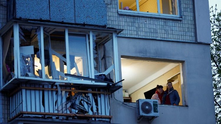 Mulheres observam a paisagem pela janela de um pr&eacute;dio danificado no local de um ataque de m&iacute;ssil russo, em meio ao ataque da R&uacute;ssia &agrave; Ucr&acirc;nia, em Kiev, Ucr&acirc;nia, em 16 de abril de 2026. REUTERS/Alina Smutko