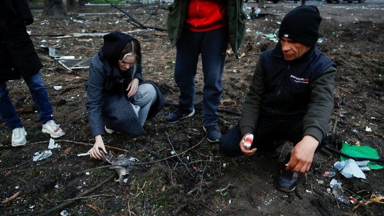 Uma mulher inspeciona um peda&ccedil;o de destro&ccedil;o enquanto outro morador observa, perto do local de um ataque de m&iacute;ssil russo, em meio ao ataque da R&uacute;ssia &agrave; Ucr&acirc;nia, em Kiev, Ucr&acirc;nia, 16 de abril de 2026. REUTERS/Alina Smutko
