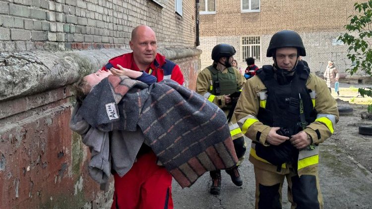 Uma profissional de sa&uacute;de carrega uma crian&ccedil;a no local de um pr&eacute;dio de apartamentos atingido por um ataque de drone russo, em meio ao ataque da R&uacute;ssia &agrave; Ucr&acirc;nia, em Zaporizhzhia, Ucr&acirc;nia, em 17 de abril de 2026. Foto tirada com um celular. REUTERS/Stringer
