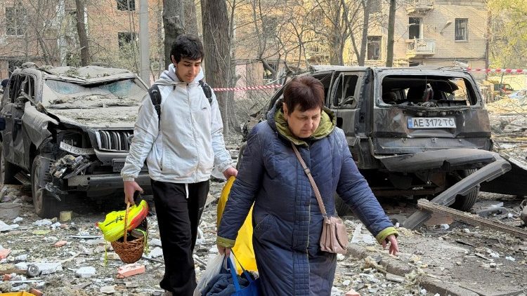 Moradores deixam o local de um pr&eacute;dio de apartamentos atingido por um ataque de drone e m&iacute;ssil russo, em meio ao ataque da R&uacute;ssia &agrave; Ucr&acirc;nia, em Dnipro, Ucr&acirc;nia, em 25 de abril de 2026. Foto tirada com um celular. REUTERS/Serhii Chalyi