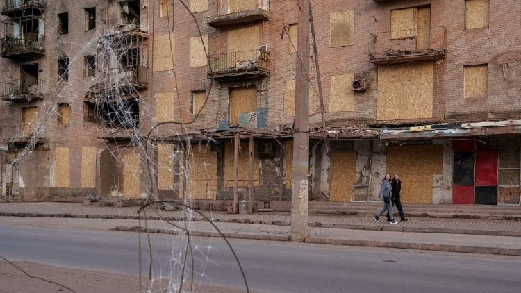 Pessoas caminham ao lado de um pr&eacute;dio danificado, em meio ao ataque da R&uacute;ssia &agrave; Ucr&acirc;nia, na cidade de Sloviansk, regi&atilde;o de Donetsk, Ucr&acirc;nia, em 25 de abril de 2026. REUTERS/Serhii Korovainyi