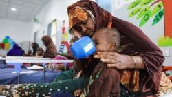 Una donna somala sfollata nutre il suo bambino presso l'ospedale di Daynile (Reuters)