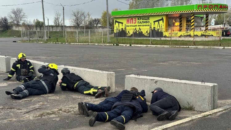 Bombeiros se abrigam com medo de uma explos&atilde;o enquanto trabalham no local de um posto de gasolina atingido por um ataque de drone russo, em meio ao ataque da R&uacute;ssia &agrave; Ucr&acirc;nia, em Kharkiv, Ucr&acirc;nia, em 1&ordm; de maio de 2026. Foto tirada com um celular. REUTERS/Vitalii Hnidyi