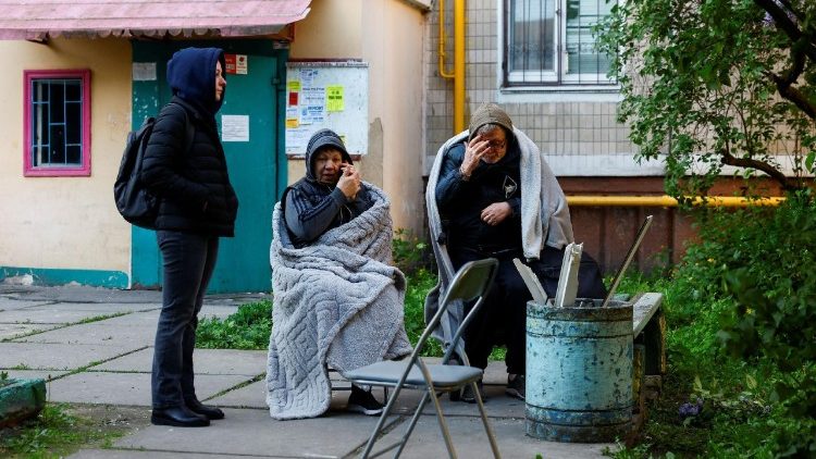 Moradores ao lado de um pr&eacute;dio parcialmente desabado, danificado durante ataques com m&iacute;sseis e drones russos, em meio ao ataque da R&uacute;ssia &agrave; Ucr&acirc;nia, em Kiev, Ucr&acirc;nia, 14 de maio de 2026. REUTERS/Valentyn Ogirenko