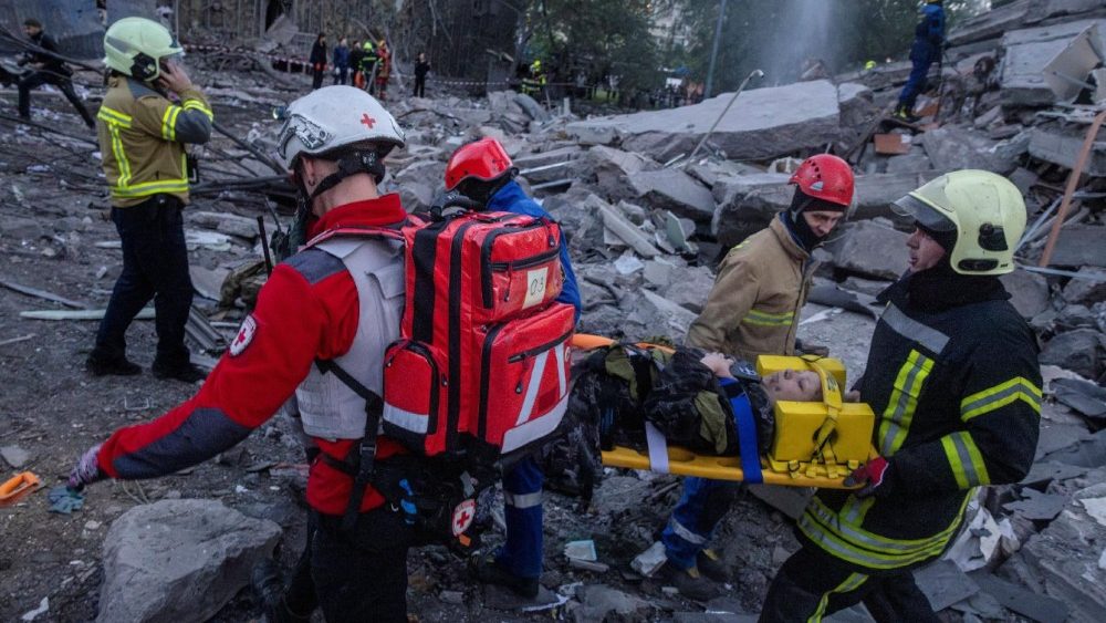Socorristas carregam uma mulher ferida dos escombros de um prédio de apartamentos que foi danificado e parcialmente desabado durante ataques com mísseis e drones russos, em meio ao ataque da Rússia à Ucrânia, em Kiev, Ucrânia, em 14 de maio de 2026. REUTERS/Thomas Peter