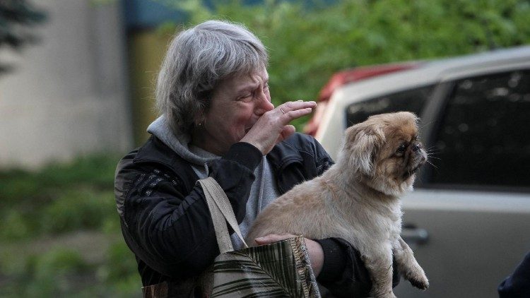 Uma mulher chora enquanto segura um cachorro no local de um pr&eacute;dio de apartamentos danificado durante um ataque de m&iacute;ssil russo, em meio ao ataque da R&uacute;ssia &agrave; Ucr&acirc;nia, em Dnipro, Ucr&acirc;nia, em 18 de maio de 2026. REUTERS/Stringer