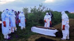 Des professionnels de santé congolais, équipés d'équipements de protection individuelle, mettent en terre le cercueil d'un patient décédé des suites d'Ebola, le 21 mai 2026.