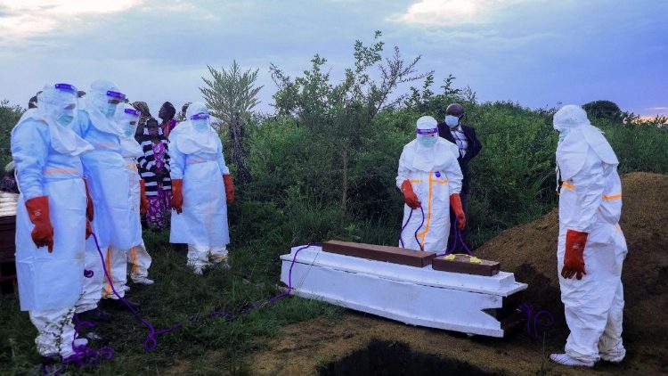 Des professionnels de santé congolais, équipés d'équipements de protection individuelle, mettent en terre le cercueil d'un patient décédé des suites d'Ebola, le 21 mai 2026.