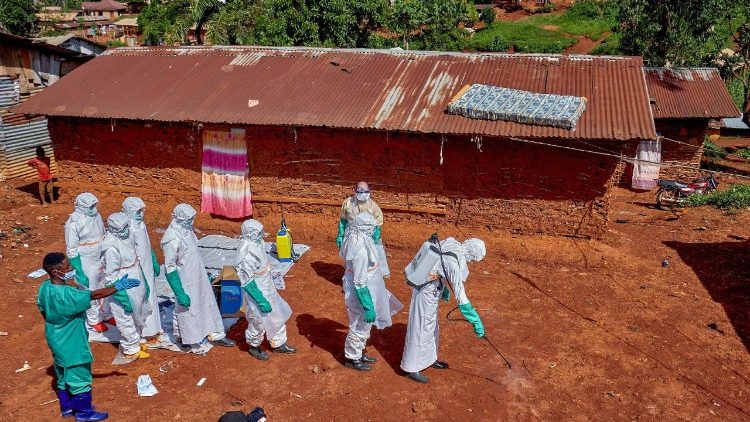 Operatori della Croce Rossa disinfettano il terreno fuori dalla casa di un uomo morto di Ebola
