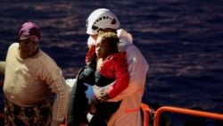 Um socorrista ajuda uma criança enquanto migrantes desembarcam de uma embarcação da guarda costeira espanhola no porto de Arguineguin, na ilha de Gran Canaria, Espanha, em 14 de novembro de 2025. REUTERS/Borja Suarez/Foto de arquivo