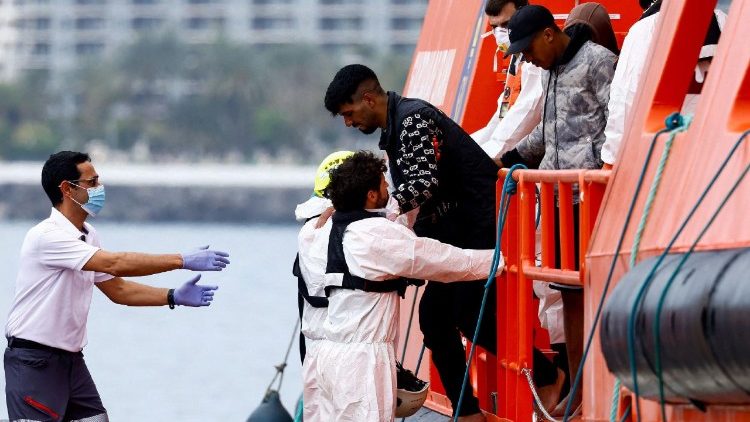 FILE PHOTO: Rescuers help a migrant disembark from a Spanish coast guard vessel at the port of Arguineguin
