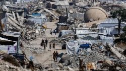 Palestinians walk past the rubble of residential buildings destroyed during the war, at the Jabalia refugee camp in Gaza