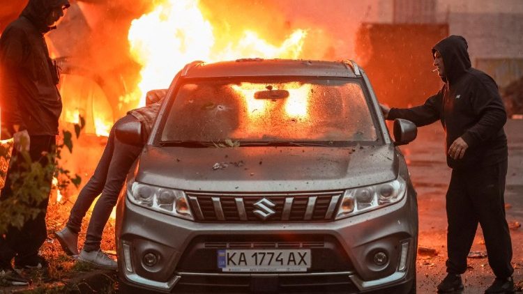Moradores tentam remover um carro de um local atingido por m&iacute;sseis e drones russos, em meio ao ataque da R&uacute;ssia &agrave; Ucr&acirc;nia, em Kiev, Ucr&acirc;nia, em 15 de junho de 2026. REUTERS/Alina Smutko