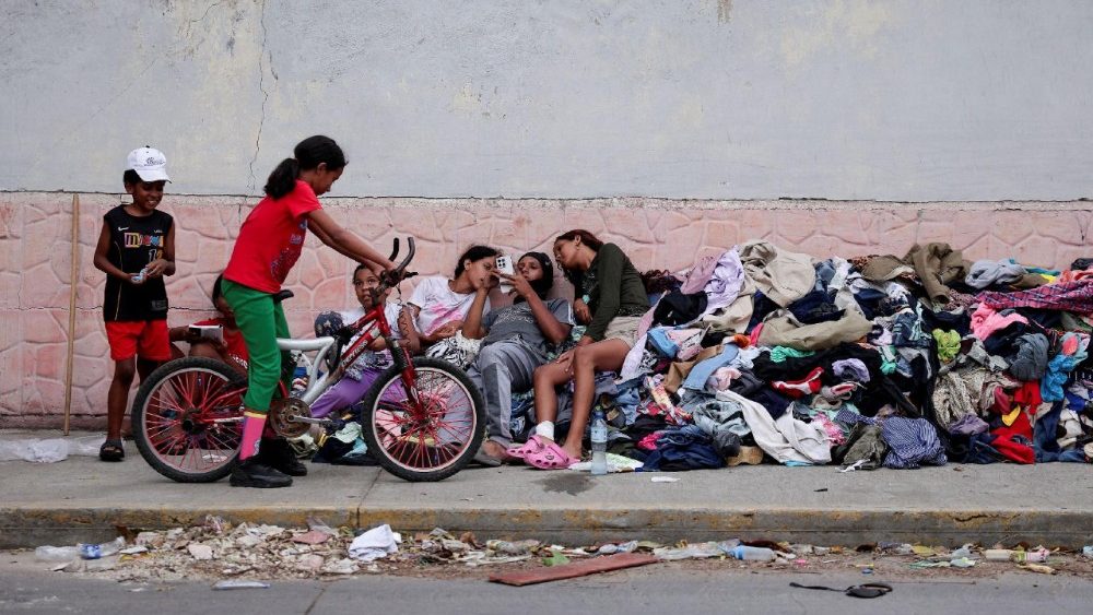 Crianças que perderam suas casas nos terremotos descansam sobre uma pilha de roupas doadas em uma rua de La Guaira, Venezuela, em 29 de junho de 2026. REUTERS/Gaby Oraa