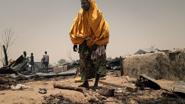 Una donna accanto ai suoi effetti personali dopo un incendio scoppiato mentre il WFP si preparava per la distribuzione di cibo nel campo profughi di Damasak, a Mobbar, nello Stato di Borno