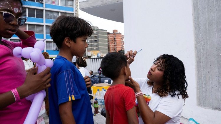 Uma volunt&aacute;ria pinta os rostos de crian&ccedil;as desabrigadas ap&oacute;s o conjunto habitacional onde moram ter sido danificado pelos terremotos de 24 de junho, deixando os moradores impossibilitados de retornar aos seus apartamentos, em Caracas, Venezuela, 5 de julho de 2026. REUTERS/Marian Carrasquero