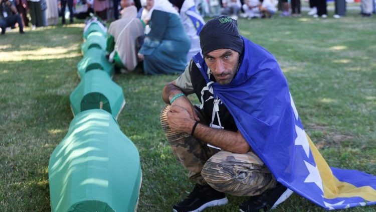 A mourner near the coffins of the ten victims buried this year