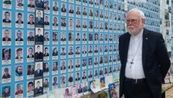 Erzbischof Paul Richard Gallagher in Kyiv vor einer Gedenkwand für im Krieg getötete ukrainische Soldaten