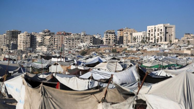 Wastewater flows next to tents sheltering displaced Palestinians, in Gaza