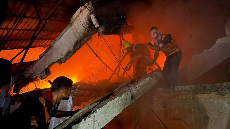 Civil Defence personnel respond following an Israeli strike on a residential apartment in Gaza City