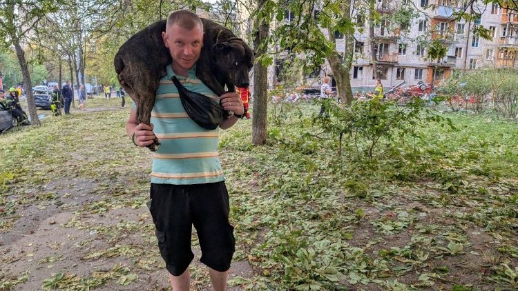 Um homem carrega seu cachorro no local de um pr&eacute;dio de apartamentos atingido por um m&iacute;ssil russo, em meio ao ataque da R&uacute;ssia &agrave; Ucr&acirc;nia, em Kiev, Ucr&acirc;nia, em 1&ordm; de agosto de 2026. Foto tirada com um celular. REUTERS/Stringer