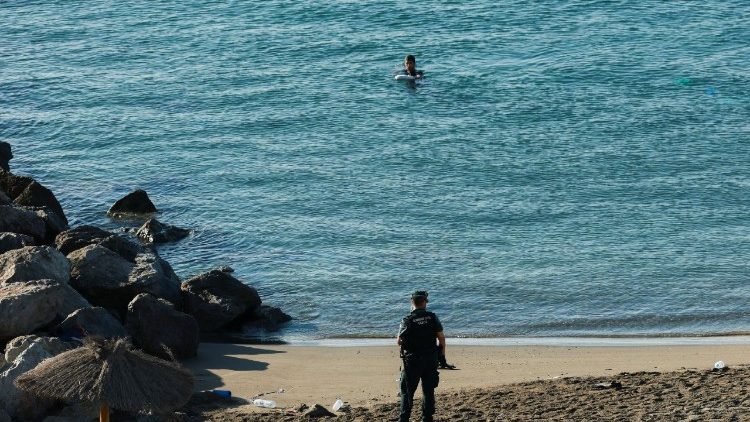 A Ceuta, enclave spagnola confinante col Marocco, un agente dellla Guardia Civil attende un giovane migrante che cerca di raggiungere a nuoto il territorio spagnolo. Decine di persone sono morte in questo tentativo