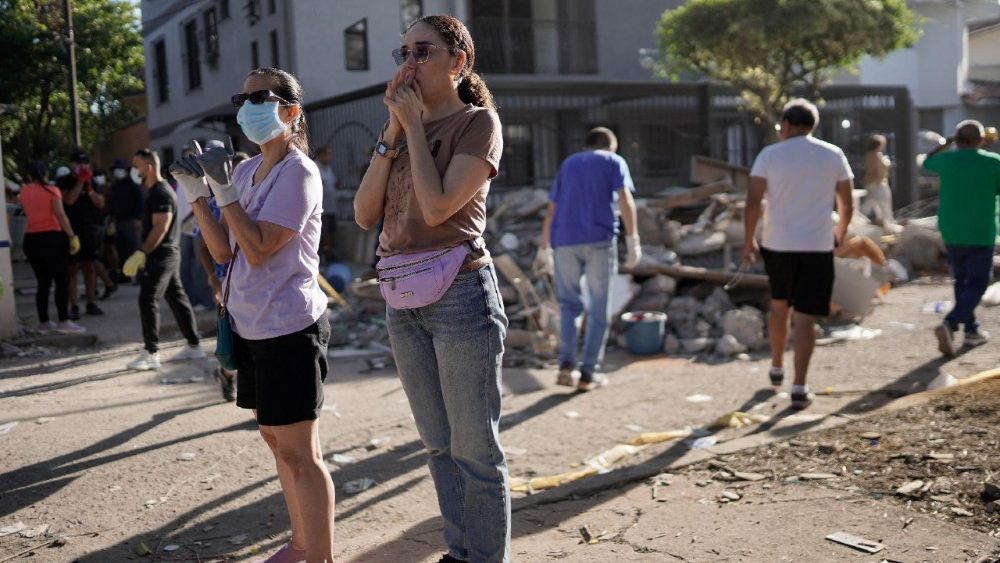Uma mulher reage enquanto pessoas procuram sobreviventes no local de um prédio que desabou, após um terremoto em Cali, Colômbia, em 11 de agosto de 2026. REUTERS/Sergio Acero