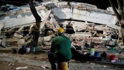 Un uomo siede vicino alle macerie dell'edificio Torres de Limonar dopo il terremoto a Cali, in Colombia