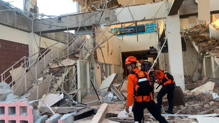 Si scava tra le macerie di un edificio vicino al porto di L. Say dopo il terremoto a Sikka