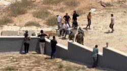 Abitanti di Qusra minacciati da coloni in un'immagine del 15 agosto (Reuters)