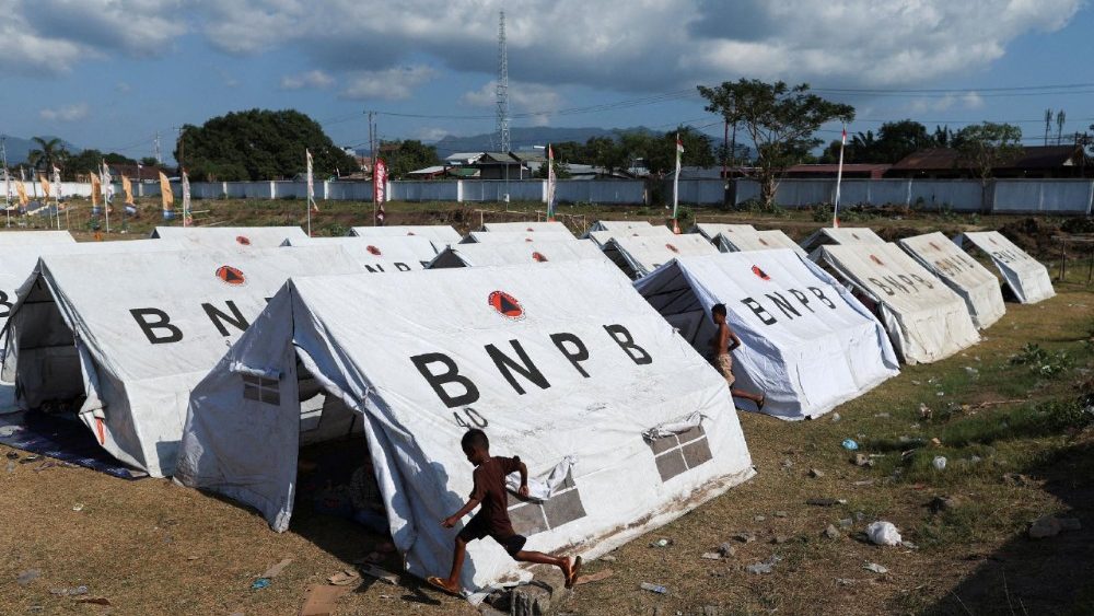 Crianças correm ao lado de abrigos em um centro de evacuação improvisado em um estádio após um terremoto em Maumere, Nusa Tenggara Oriental, Indonésia, em 16 de agosto de 2026. REUTERS/Edgar Su