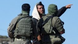 Soldati israeliani parlano con un colono israeliano a Qusra