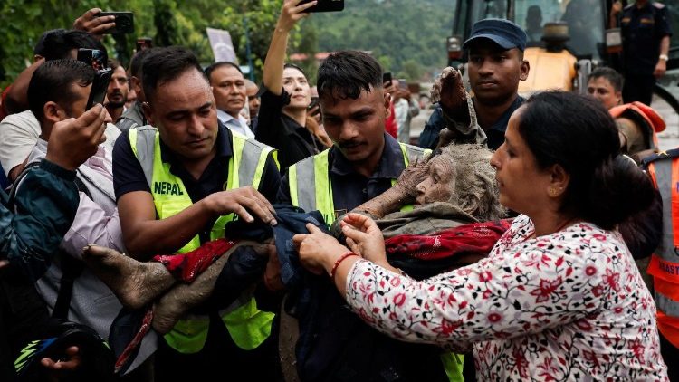 Agenti di polizia trasportano un'anziana sopravvissuta alle inondazioni dopo l'alluvione a Trishuli, Nepal