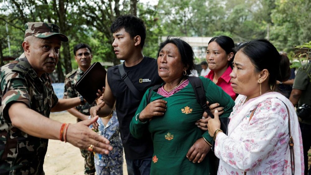 Uma mulher é consolada ao chegar ao Quartel Maithali, um centro de treinamento do exército que serve como base principal para o transporte aéreo de sobreviventes do distrito de Rasuwa, após enchentes repentinas e um deslizamento de terra, em Trishuli, distrito de Nuwakot, Nepal, em 28 de agosto de 2026. REUTERS/Navesh Chitrakar
