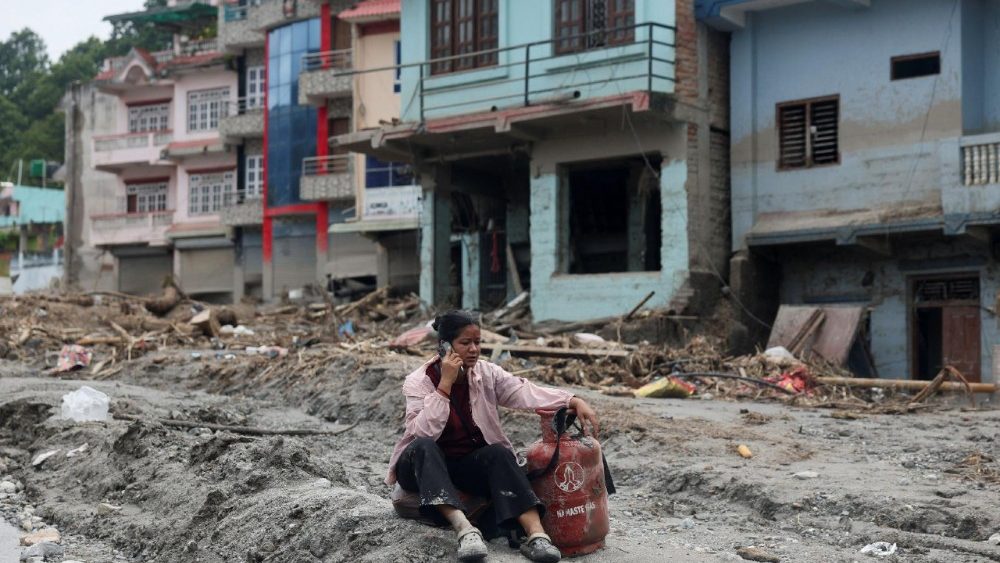 Uma mulher fala ao telefone sentada ao lado de um cilindro de gás no local de enchentes repentinas e deslizamentos de terra em Devighat, distrito de Nuwakot, Nepal, em 29 de agosto de 2026. REUTERS/Francis Mascarenhas