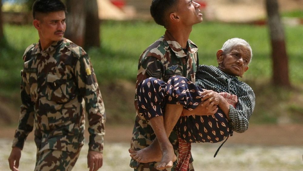 Um soldado do exército carrega uma pessoa que foi evacuada de uma área afetada por enchentes repentinas e um deslizamento de terra, no Quartel Maithili, um centro de treinamento do exército, em Trishuli, distrito de Nuwakot, Nepal, em 30 de agosto de 2026. REUTERS/Francis Mascarenhas