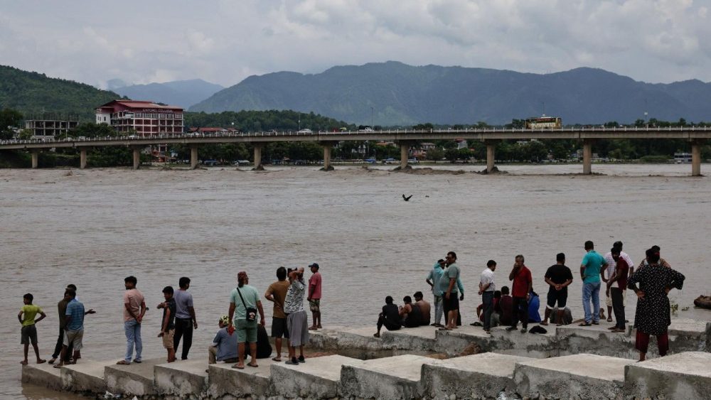 Pessoas observam o aumento do nível da água no rio Narayani, após enchentes repentinas e deslizamentos de terra mortais, em Chitwan, Nepal, em 30 de agosto de 2026. REUTERS/Navesh Chitrakar