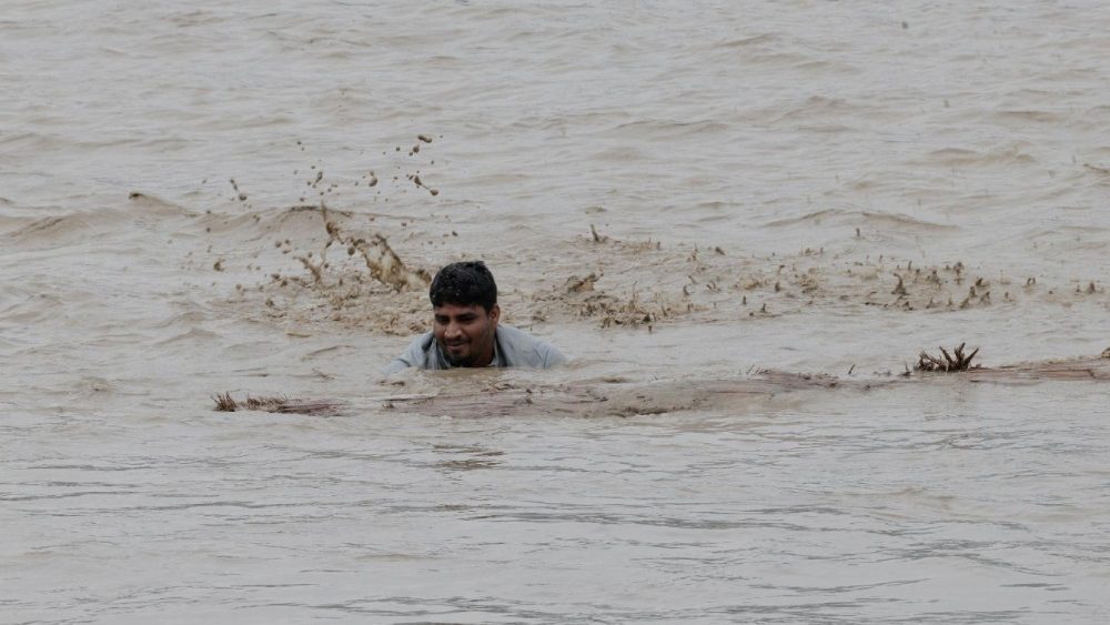 Um homem tenta recuperar um tronco do rio Narayani, durante a cheia causada por enchentes repentinas e deslizamentos de terra, em Chitwan, Nepal, em 30 de agosto de 2026. REUTERS/Navesh Chitrakar
