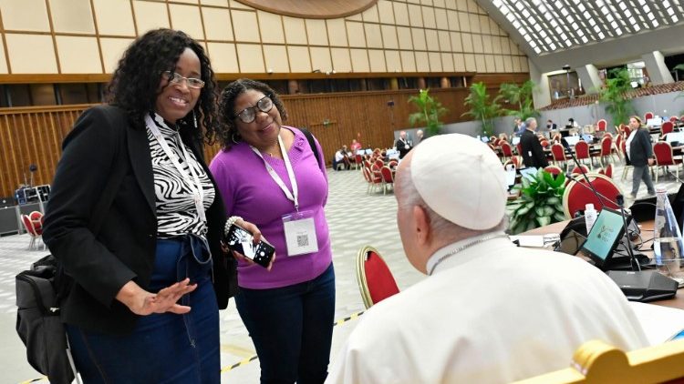 Papež František v synodní aule hovoří se dvěma účastnicemi synody