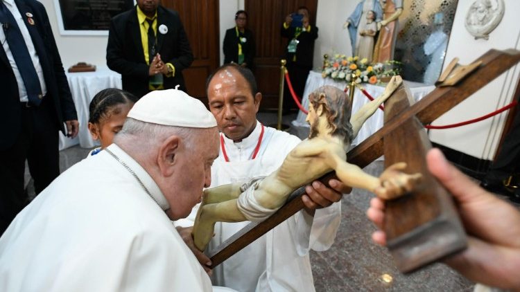 El Papa besa la cruz a su llegada a la catedral de Dili