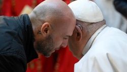 Papež po otevření Svaté brány v římské věznici Rebibbia naslouchá jednomu z vězňů