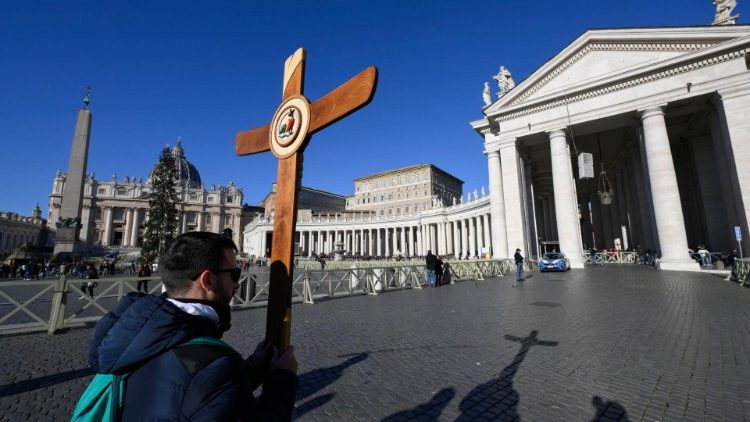 Kříž se skupinou poutníků na Svatopetrském náměstí