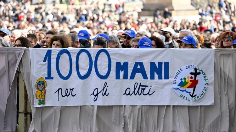 Uno striscione dei volontari radunati in San Pietro per il Giubileo