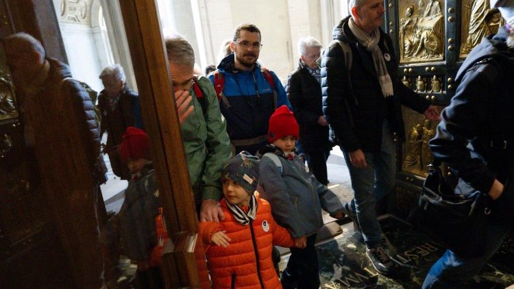 Pellegrini di Napoli attraversano la Porta Santa della basilica Vaticana 
