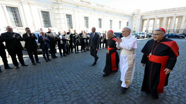 Il Papa si dirige verso l'Aula del Sinodo per l'incontro con i cardinali, salutato da una fila di sacerdoti