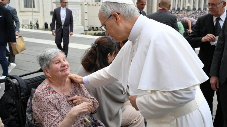 Pope Leo XIV speaks to a woman attending the General Audience on May 21, 2025