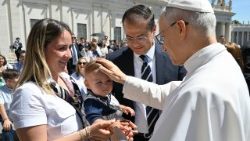 Le Pape Léon XIV bénissant un enfant lors de l'audience générale du mercredi 28 mai place Saint-Pierre. 