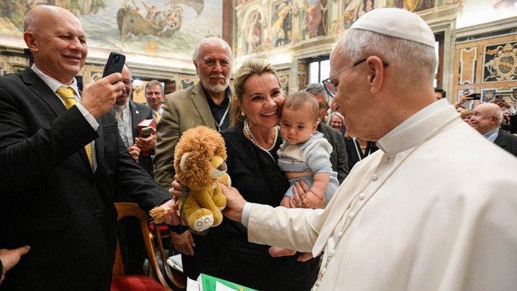 Leone XIV riceve in dono un leone di peluche da una giovane famiglia. 