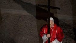 Papież niesie krzyż na Drodze Krzyżowej w Koloseum